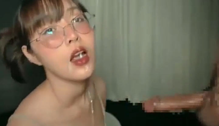 [thailand] a beautiful woman with glasses is receiving two large penises, one on each side, and her face is covered in cum, which she seems to enjoy.