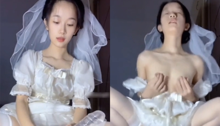 Glamourous dan seksi, gadis dewasa dalam gaun perkahwinan putih bermain sendiri secara seksi.